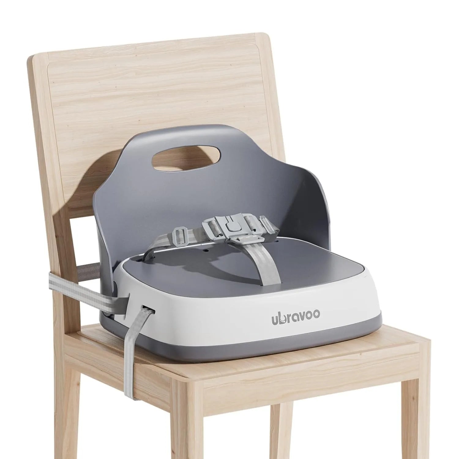 Rehausseur de chaise bébé gris sanglé sur une chaise en bois clair